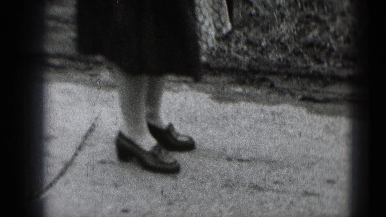 Cropped 8mm frame from Middletown, Pennsylvania, showing a woman's lower legs and dark shoes on a concrete path.