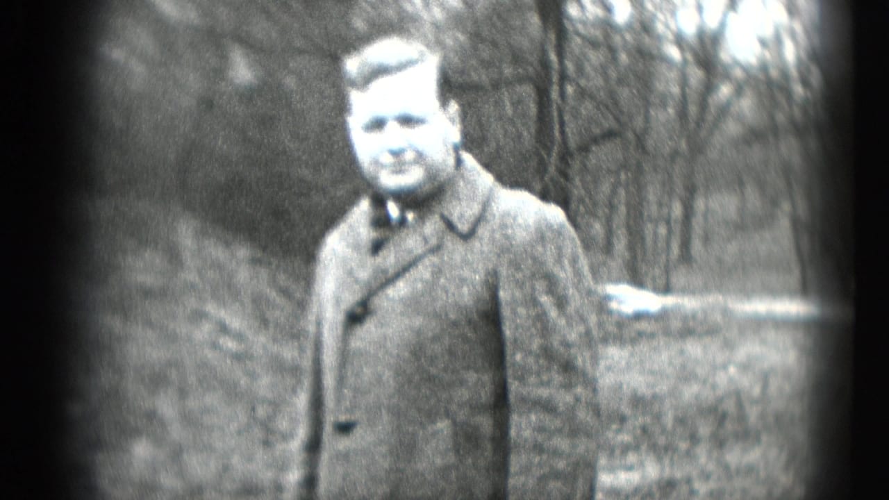 Adult man in a heavy winter coat and tie faces the camera in a wooded Middletown, Pennsylvania home-movie frame from 1948.