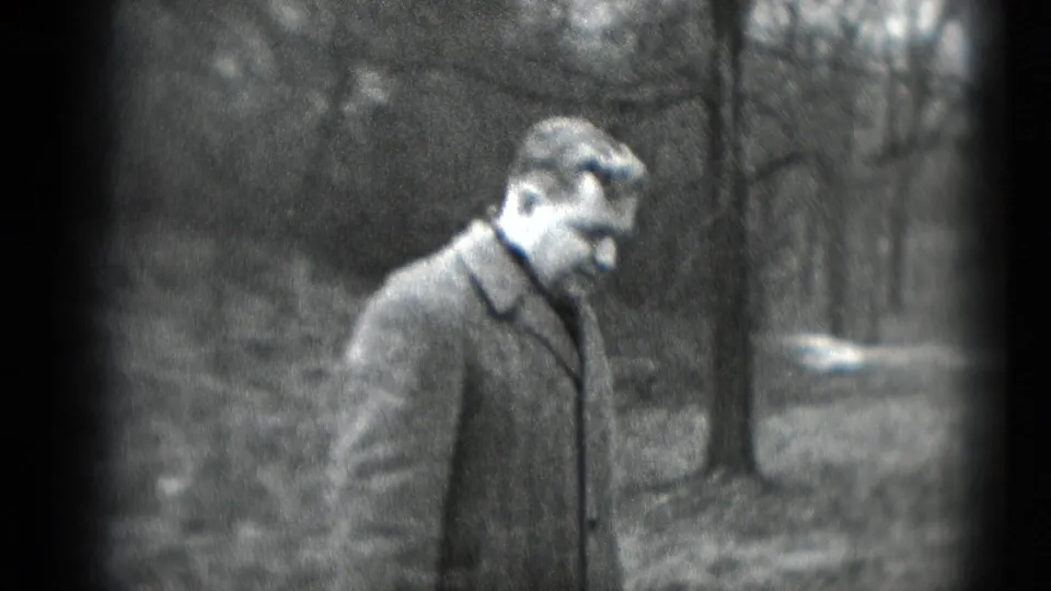 A man in a coat stands alone near trees in the wooded Middletown footage, his face partly visible as he turns near the camera.