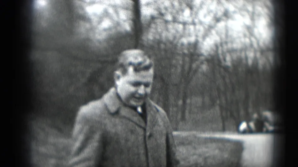 Man in a wool overcoat and tie walks outdoors in Middletown, Pennsylvania, in 1948 home-movie footage.