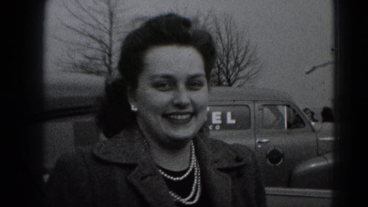 Smiling woman in late-1940s Middletown, Pennsylvania home-movie footage, with a parked car and bare trees behind her.