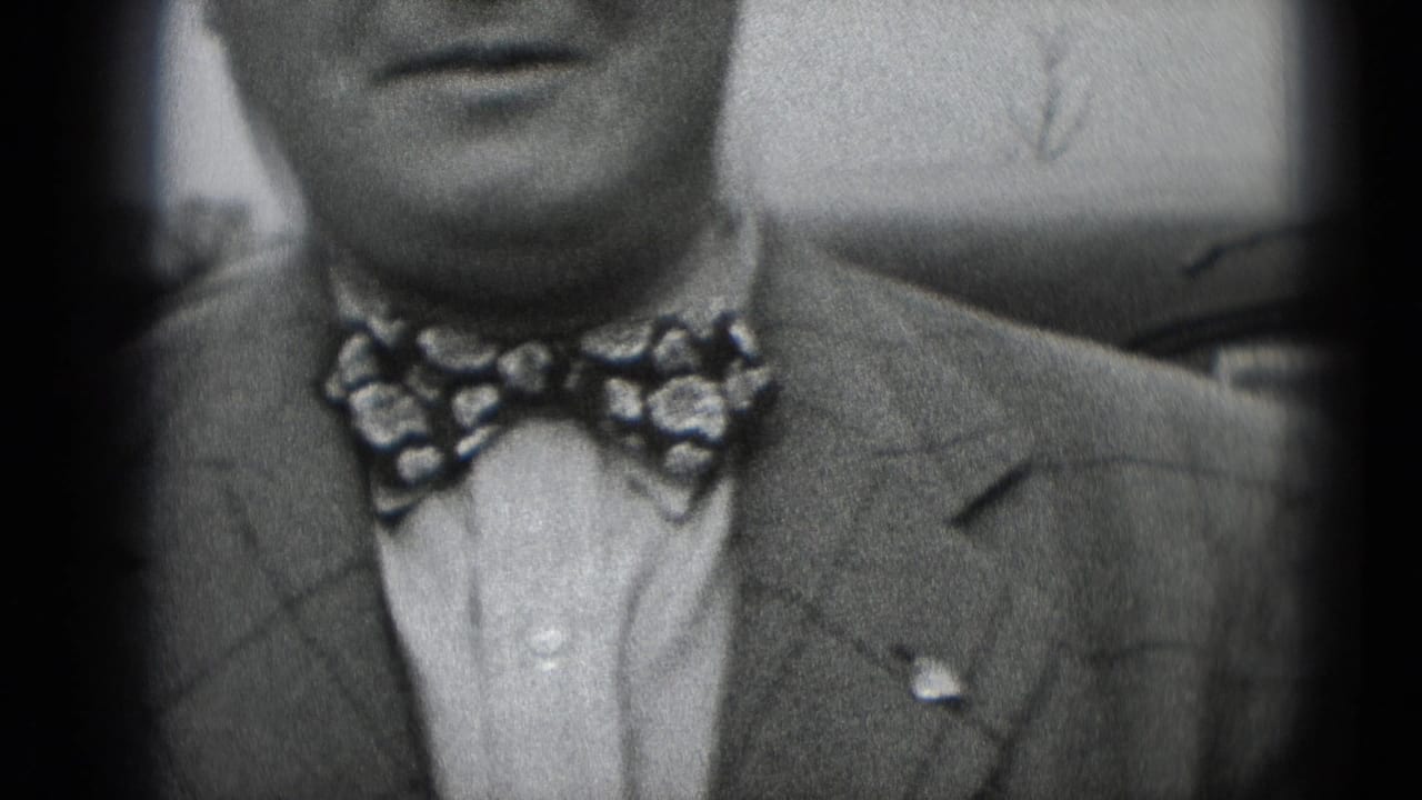 Close 1948 8mm frame of a man in a suit and patterned bow tie facing the camera in Middletown, Pennsylvania.