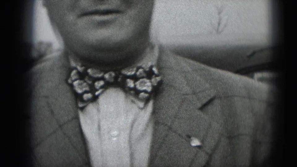 Close 1948 8mm frame of a man in a suit and patterned bow tie facing the camera in Middletown, Pennsylvania.