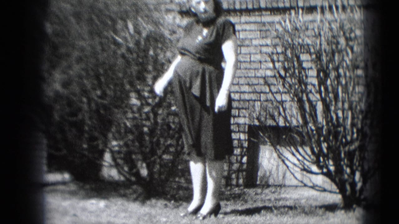 In Middletown, Pennsylvania home-movie footage from 1948, a pregnant woman stands outdoors by a brick wall with a telephone receiver.