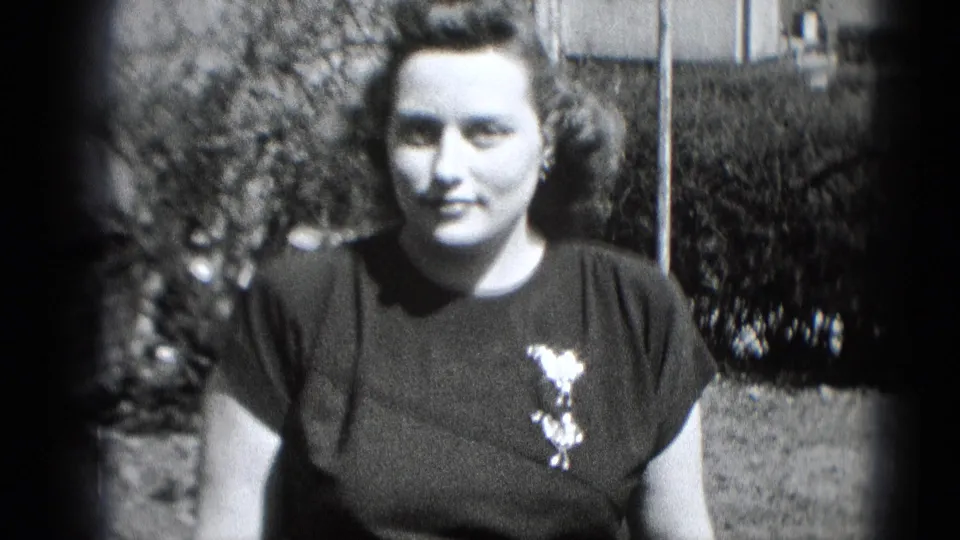 A dressed-up woman faces the camera outdoors in Middletown, Pennsylvania, with styled hair and a brooch on her dark dress.
