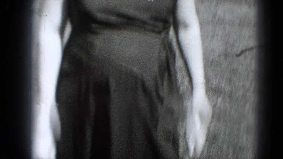 A closer, partly cropped view shows the woman's dark dress and arm outdoors on a lawn in the same Middletown home-movie scene.
