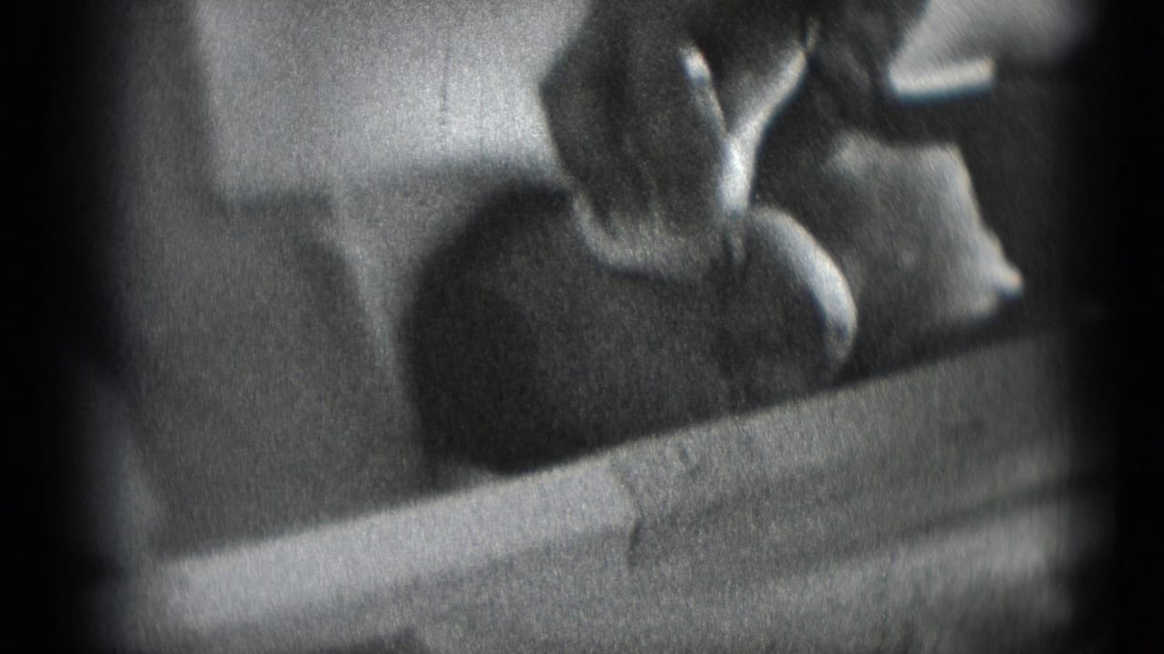 Soft 8mm frame of a baby being tended by an adult hand in a private Middletown, Pennsylvania home-movie scene.