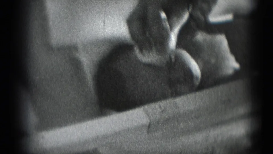Soft 8mm frame of a baby being tended by an adult hand in a private Middletown, Pennsylvania home-movie scene.