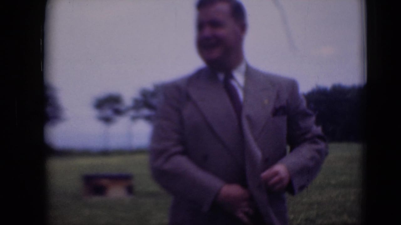 In Middletown, Pennsylvania, a smiling man in a gray suit stands outdoors on a grassy plain in 1948 home-movie footage.