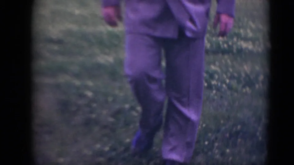 The final frame crops the man at the torso and legs as he steps through the grassy Middletown field in 1948 home-movie footage.