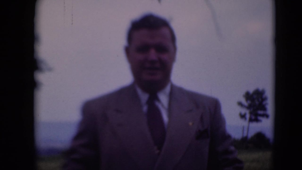 Adult man in a light suit poses outdoors in Middletown, Pennsylvania, on 1948 8mm home-movie footage.
