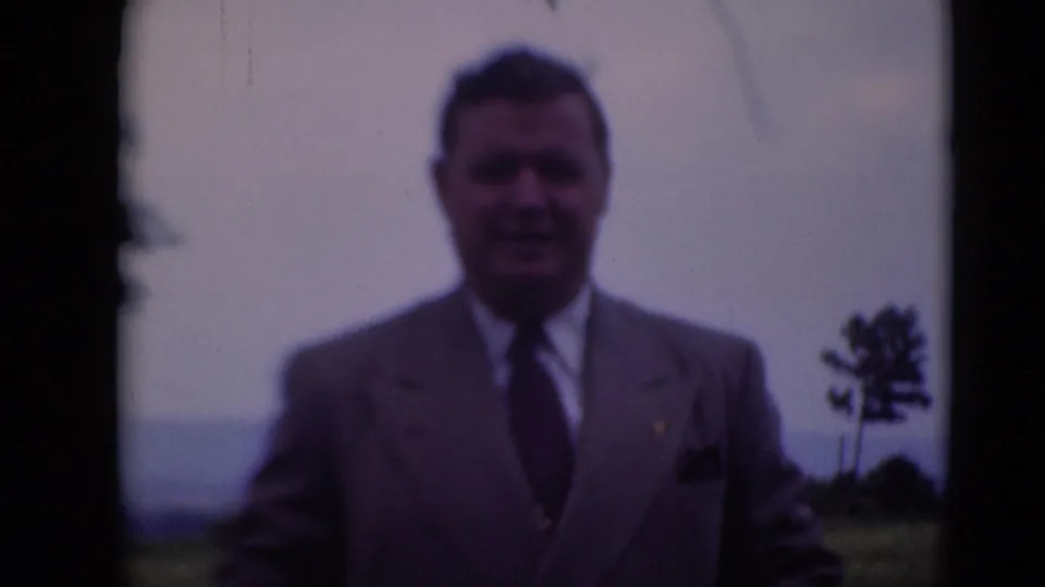 Adult man in a light suit poses outdoors in Middletown, Pennsylvania, on 1948 8mm home-movie footage.