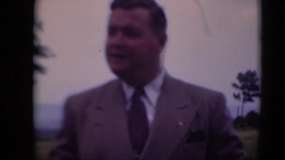 A man in a light suit and patterned tie stands in a field near Middletown, Pennsylvania, in late-1940s 8mm home-movie footage.