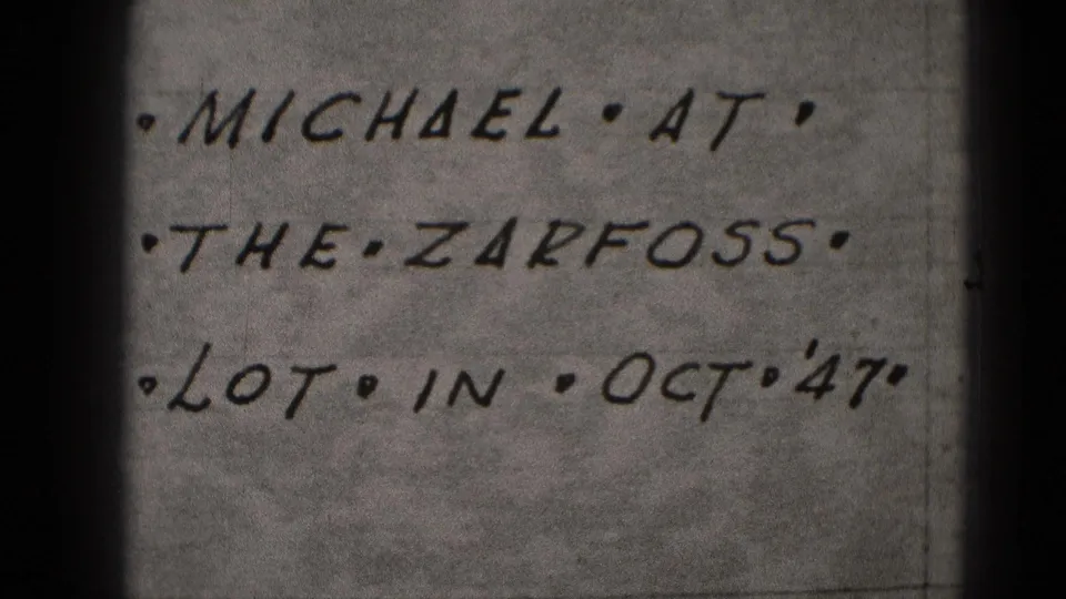 Close-up frame of the handwritten note, still legible as Michael at the Zarfoss lot in Oct '47, with visible 8mm texture.