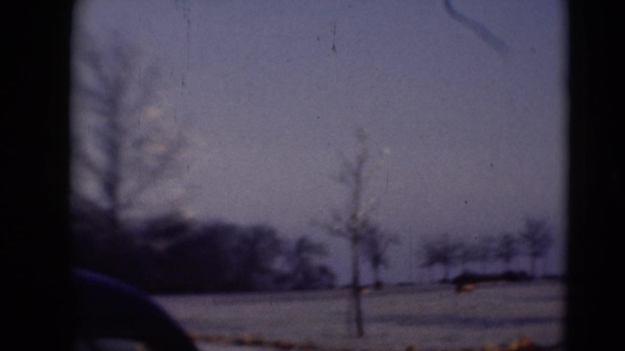 Scanned 8mm frame of a quiet winter landscape near Middletown, with bare trees, snow cover, and a dark foreground edge from the film frame.