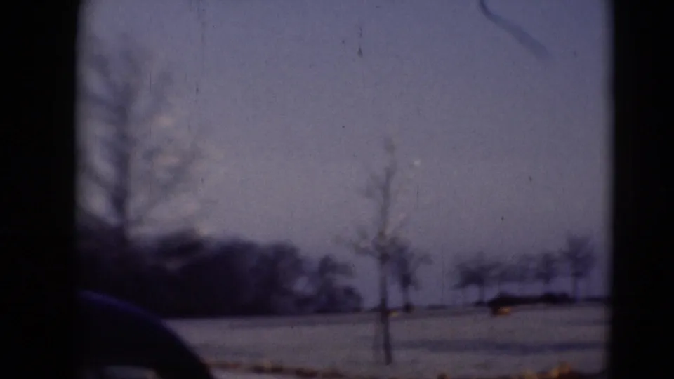 Scanned 8mm frame of a quiet winter landscape near Middletown, with bare trees, snow cover, and a dark foreground edge from the film frame.
