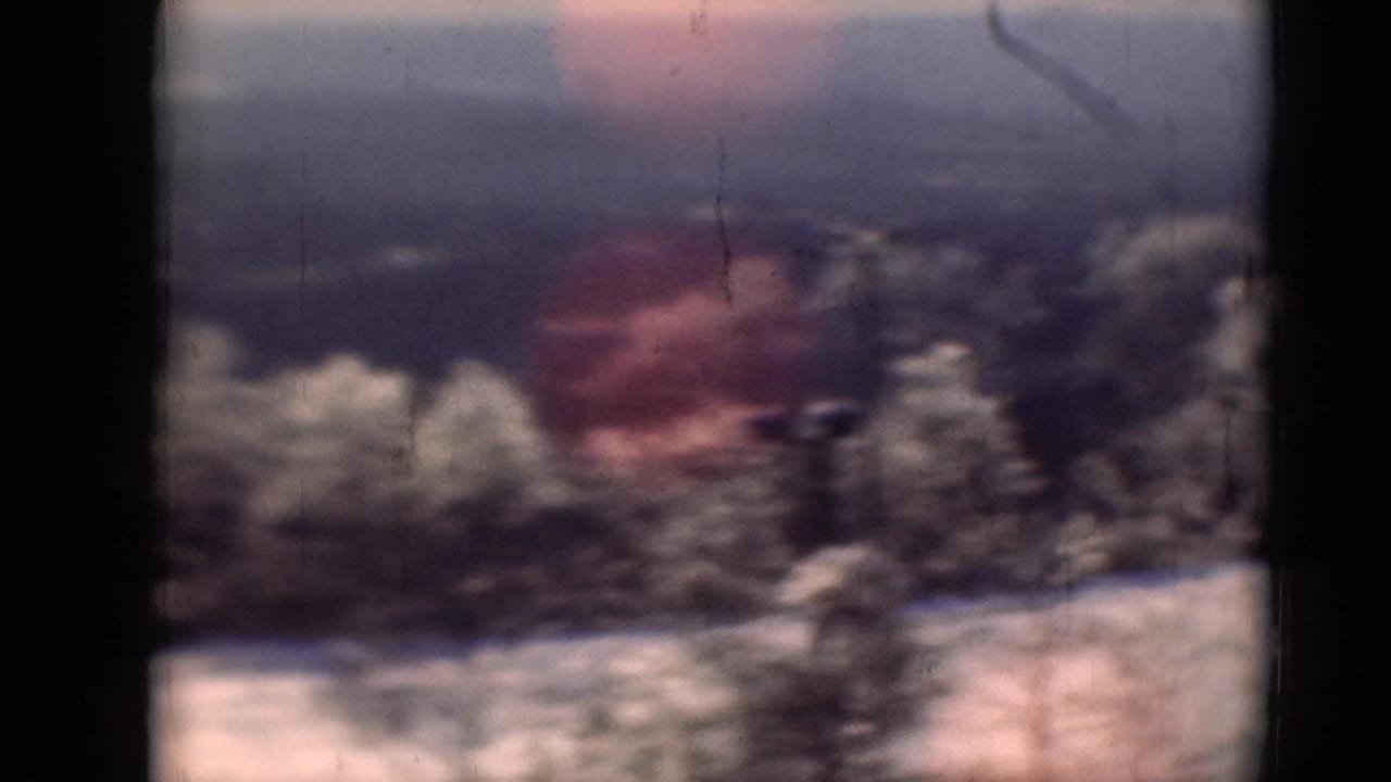 1940s 8mm home-movie frame near Middletown, Pennsylvania, showing bare trees, pale ground, and a distant brown building.