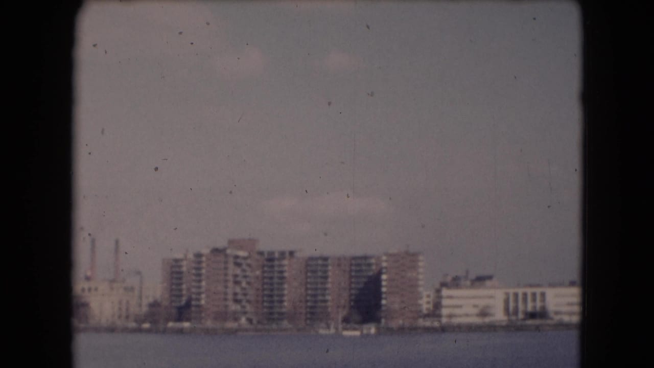 Reported Middletown, Pennsylvania waterfront view with distant apartment buildings, industrial stacks, haze, and visible 8mm film borders.