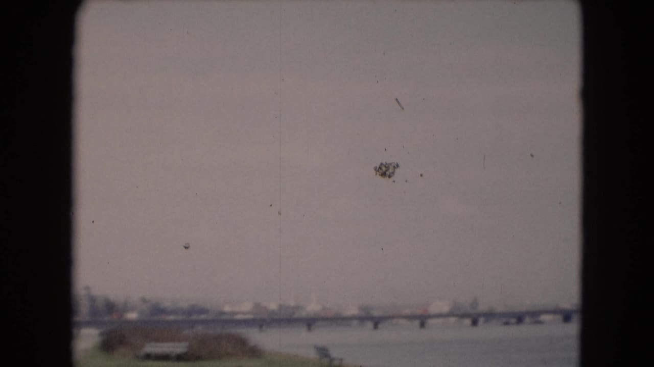Late-1940s 8mm view of a bridge over water near Middletown, Pennsylvania, with a grassy riverside foreground and bench.