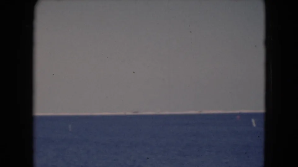 1940s 8mm frame showing a broad water horizon and pale sky from a visitor-shot viewpoint.