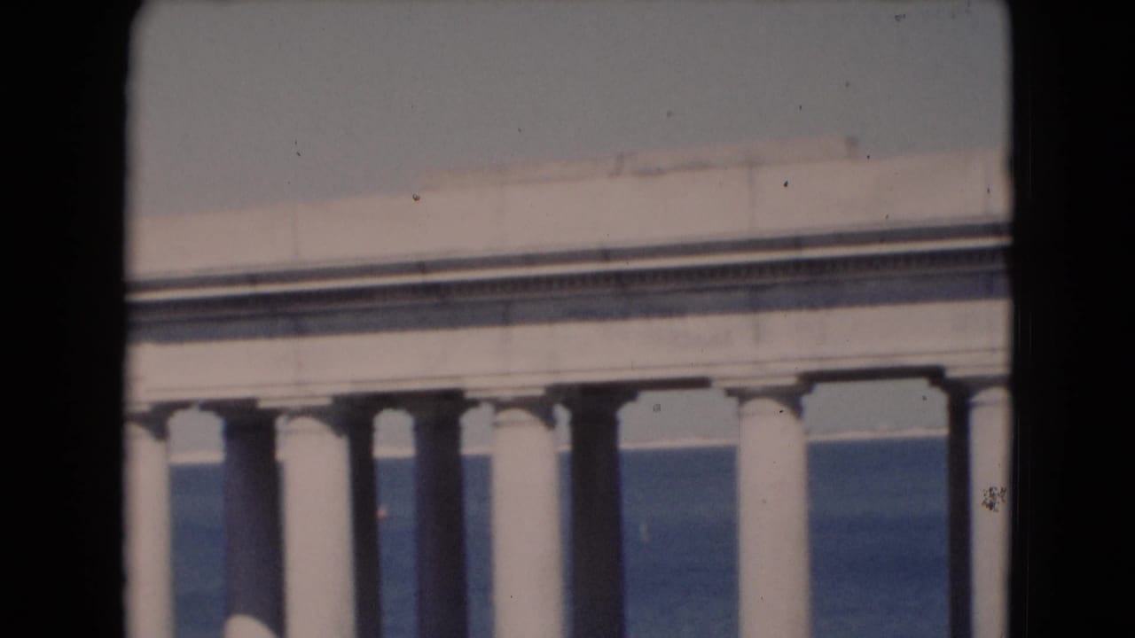 Partial view of a columned or walled structure at the edge of the film frame.