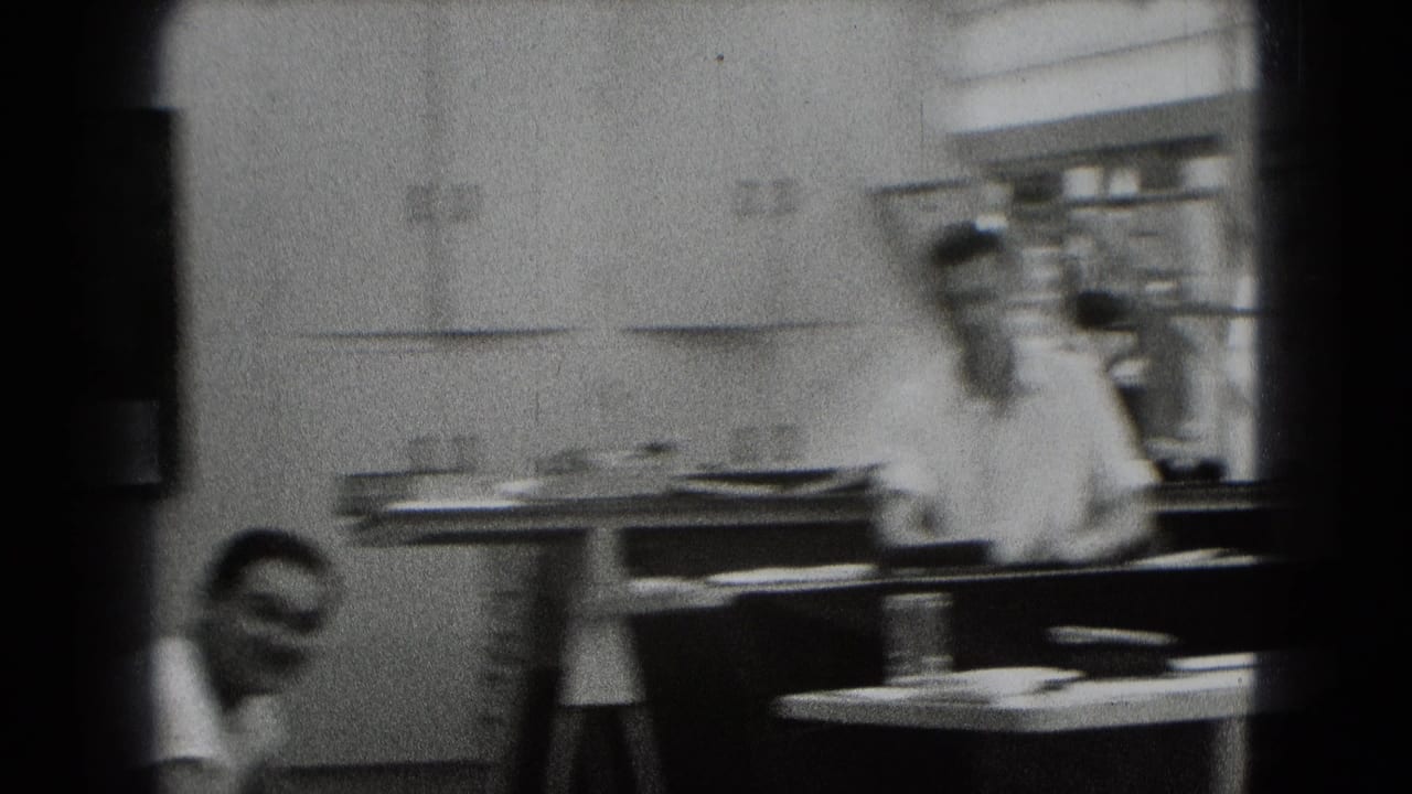 A 1948 Middletown interior frame shows a man by a cluttered table, with another smiling man partly visible in the foreground.