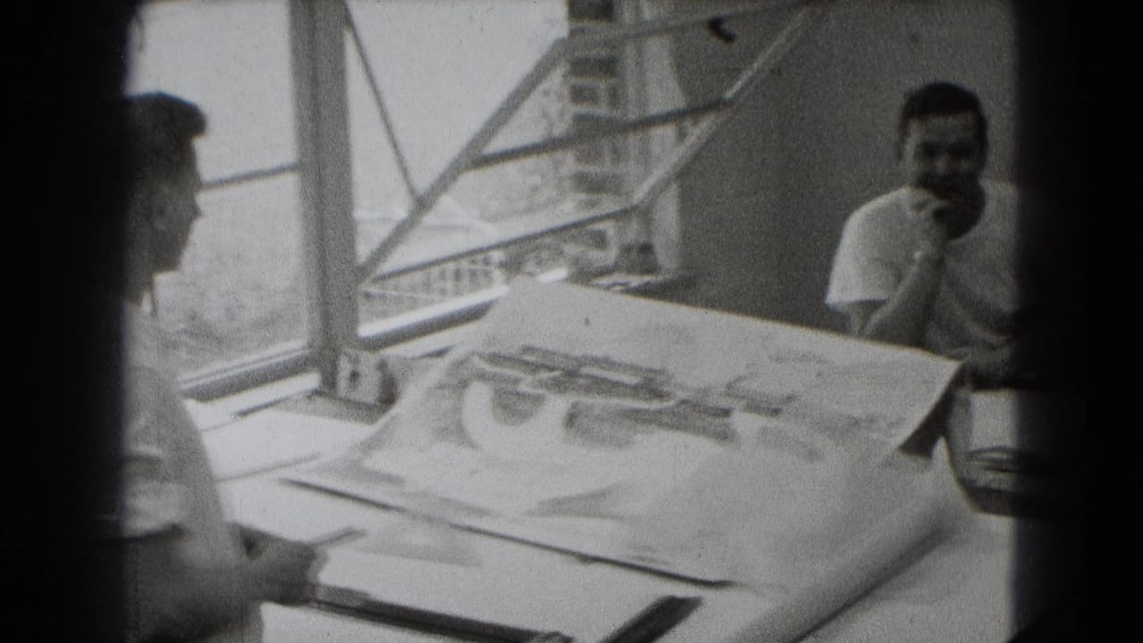 Three men appear in a black-and-white Middletown interior, with large plans spread across a table by an open window.