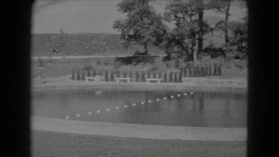 A black-and-white 8mm view of the recreation area shows the roped water, grassy shoreline, scattered trees, and low hills beyond Middletown.