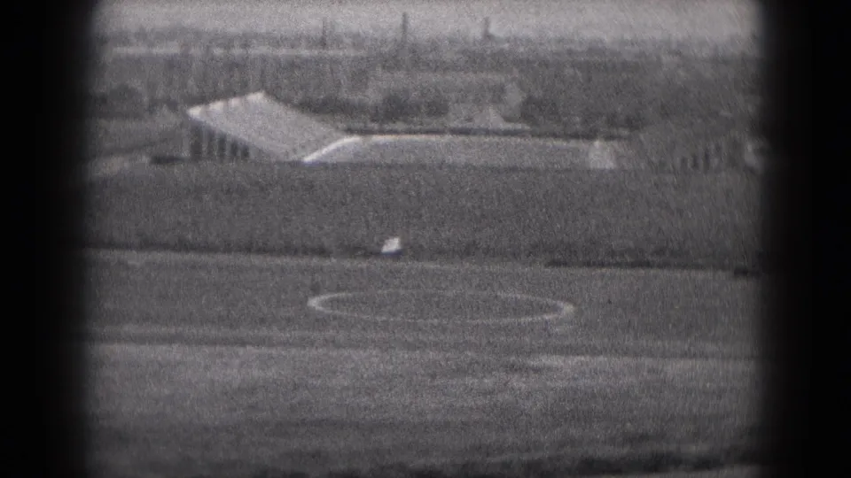 Small airplane at a rural Middletown, Pennsylvania airfield in 1975, seen through grainy black-and-white 8mm framing.
