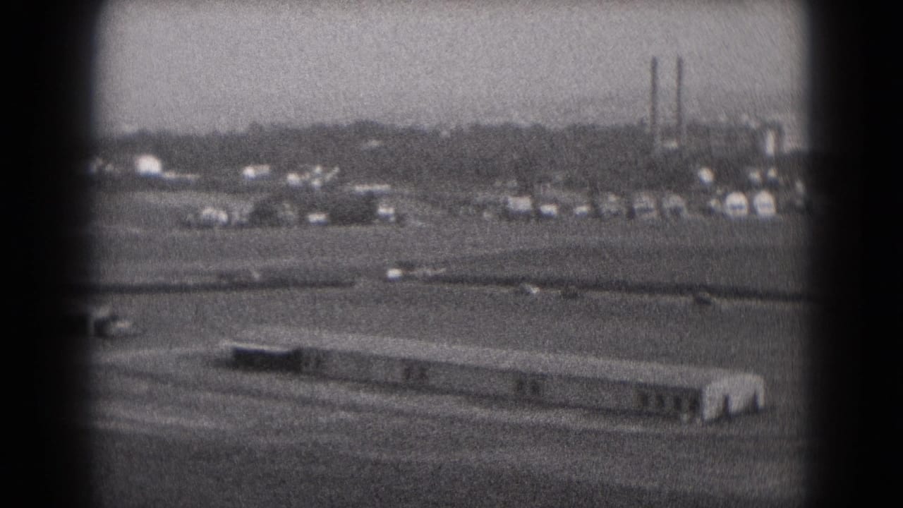 Small aircraft visible during an approach over Middletown, Pennsylvania airport grounds, with low buildings and stacks in the distance.