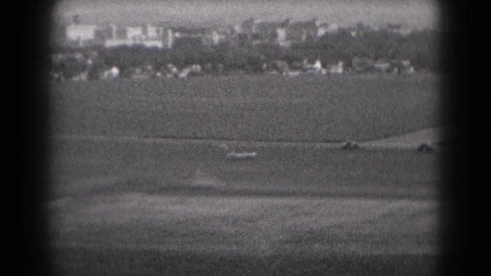 Middletown-area buildings and small houses appear across open ground in grainy 1975 black-and-white 8mm footage.