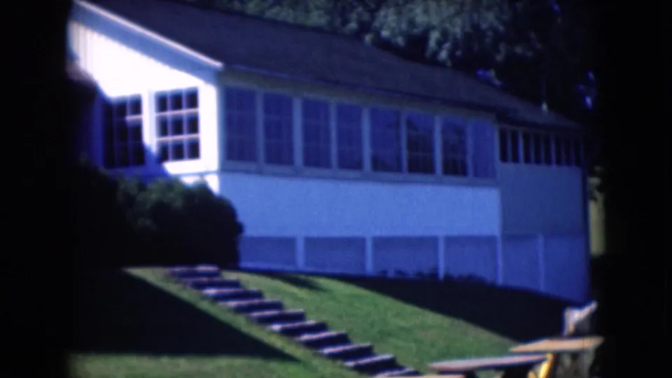 1975 Middletown, Pennsylvania view of a white house facade, broad windows, sloped lawn, steps, and a picnic table.