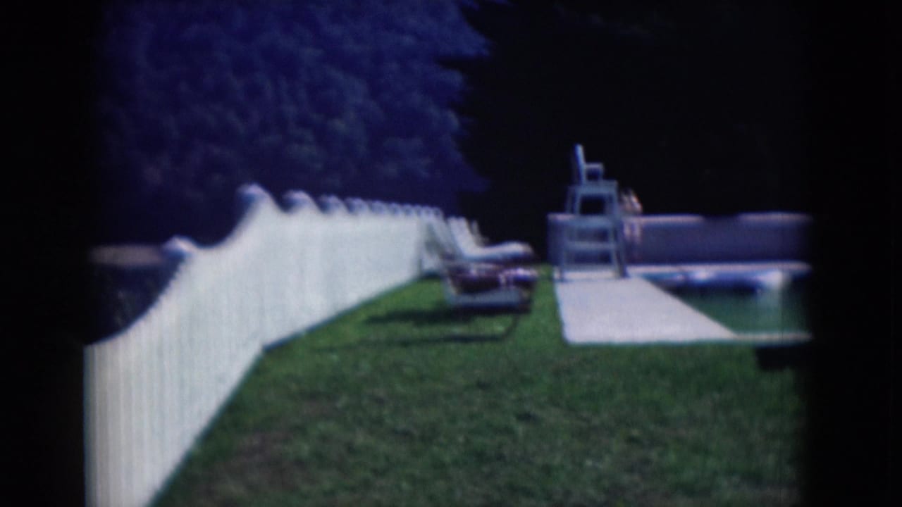 1975 Middletown, Pennsylvania backyard view with grass lawn, white picket fence, lounge chair, walkway, trees, and pool area.