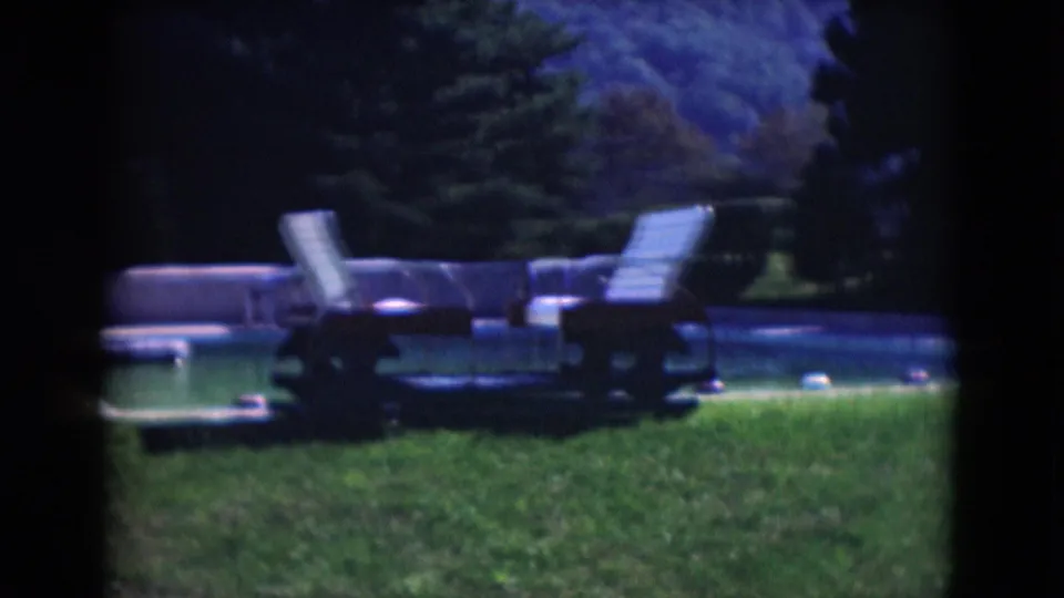 1975 Middletown backyard pool view with lawn chairs, grass, trees, pool edge, and dark 8mm contact-sheet borders.