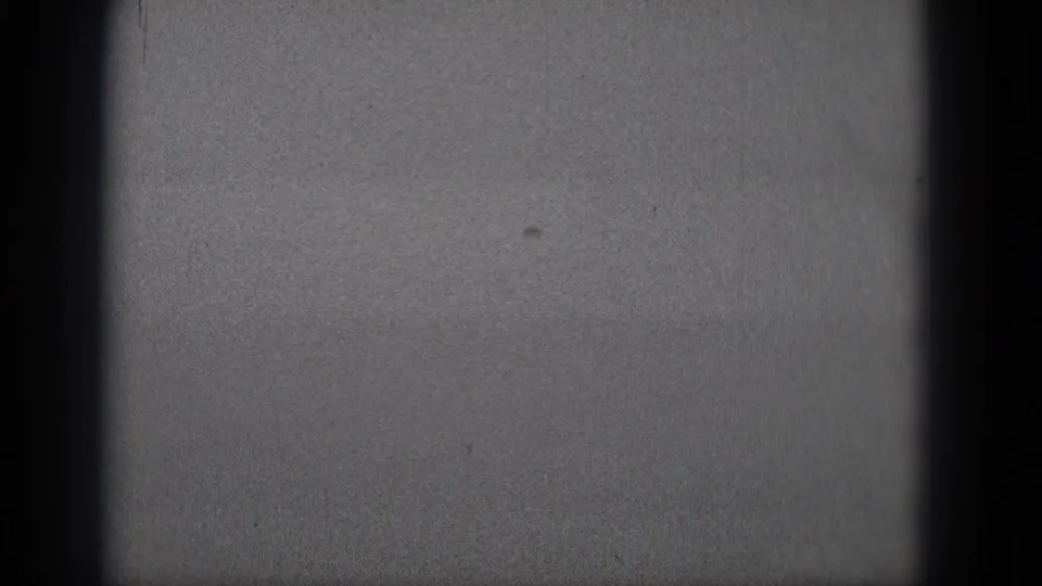Middletown 1975 metadata frame showing 8mm grain, gate edges, and a horizontal contact-sheet seam.