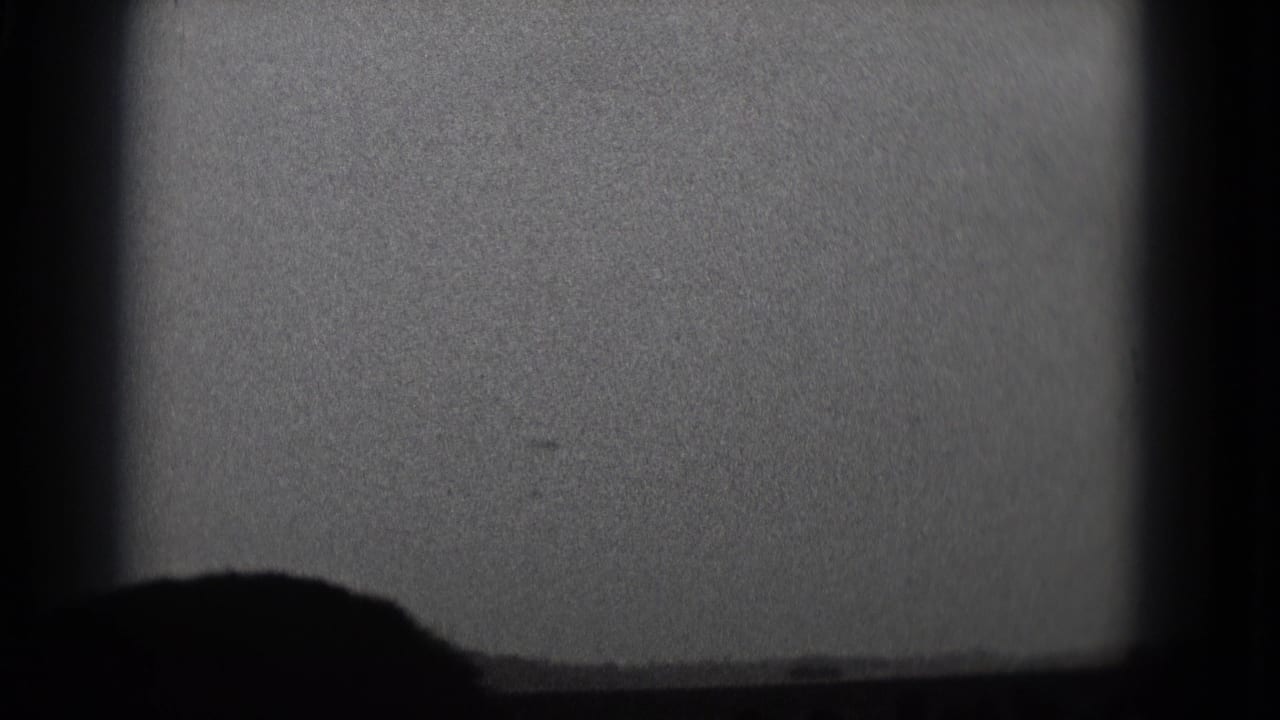 Projection screen with a large dark silhouette near the lower center.