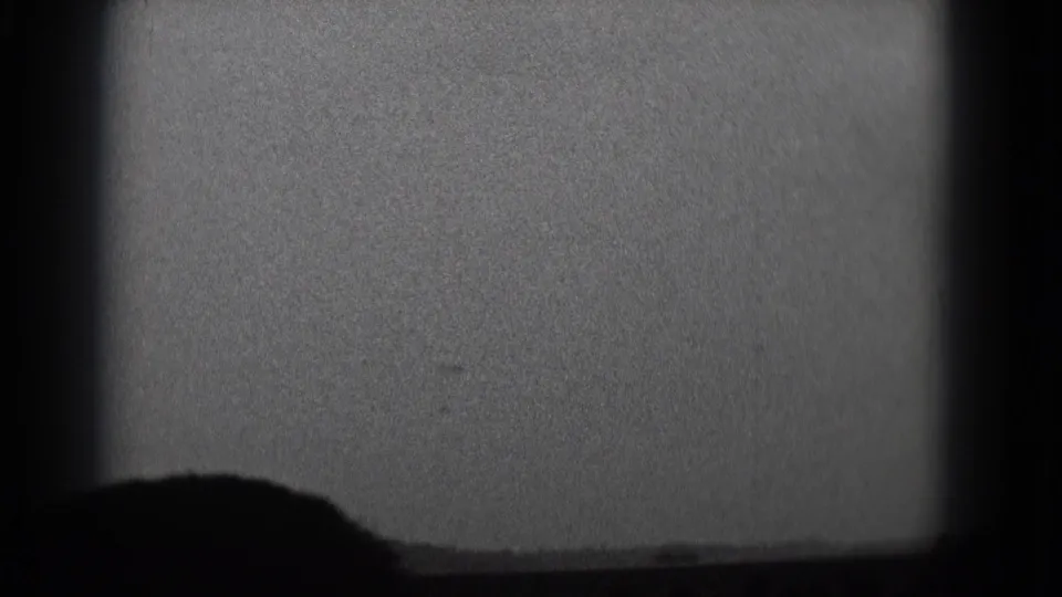 Black-and-white 8mm view of a theater screen in Middletown, Pennsylvania, with a seated viewer silhouetted in front.