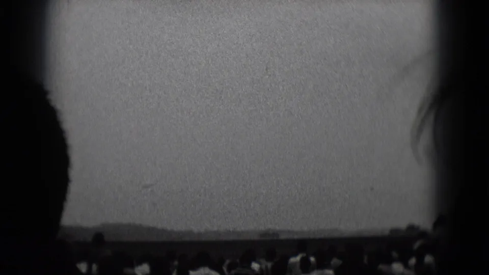 Middletown, Pennsylvania 1975 8mm frame with multiple audience silhouettes below a blank theater screen.