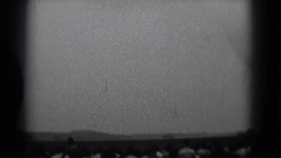 1975 Middletown, Pennsylvania 8mm frame showing spectators in silhouette beneath a bright sky or screen-like field.