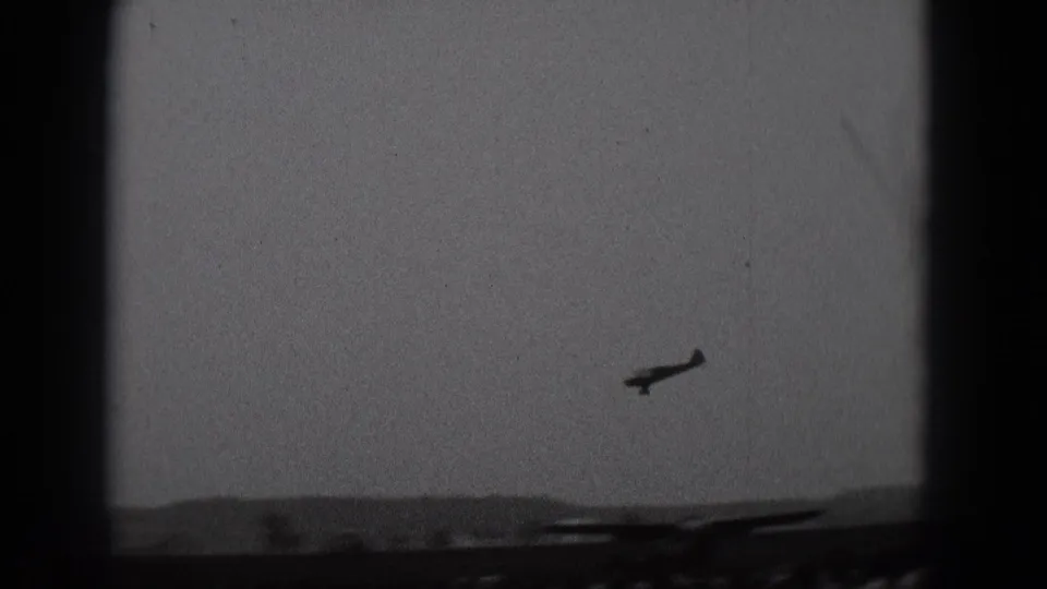 The 1975 Middletown footage shows a small plane silhouetted over a low horizon with dark foreground shapes.