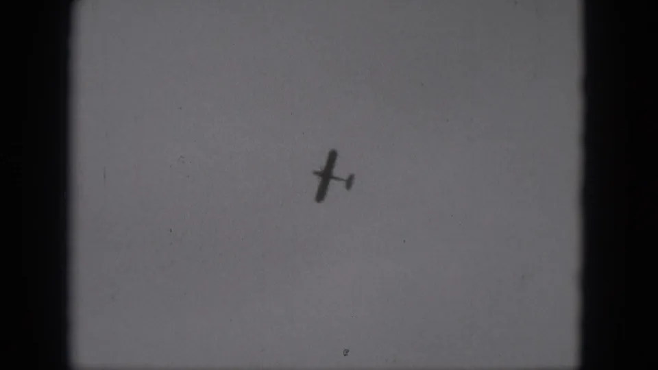 The aircraft remains small and dark against a plain sky in this 1975 Middletown, Pennsylvania home-movie frame.