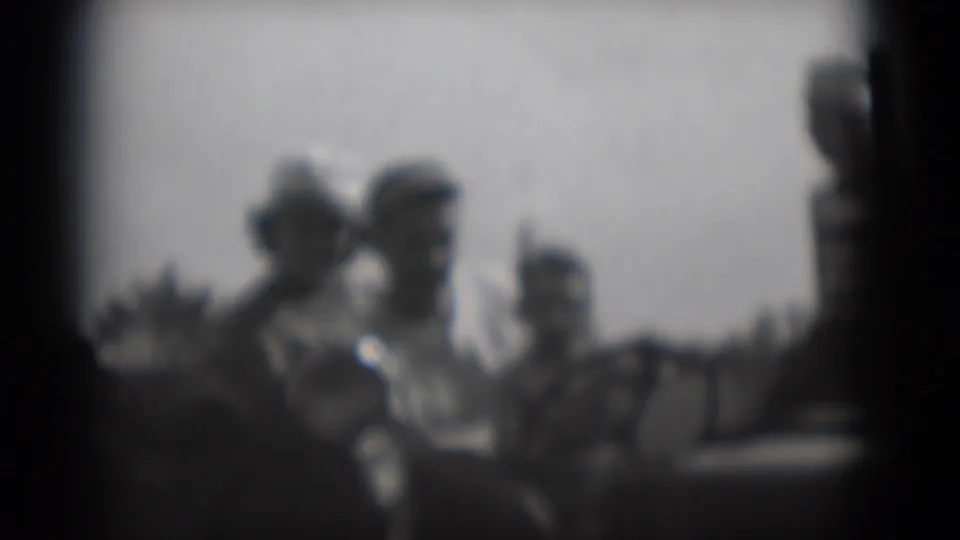 Soft 1975 8mm frame from Middletown, Pennsylvania, showing several indistinct adults gathered outdoors in bright daylight.