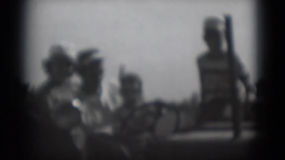 Black-and-white 8mm frame of an outdoor group in Middletown, Pennsylvania, with one taller person standing near the right side.