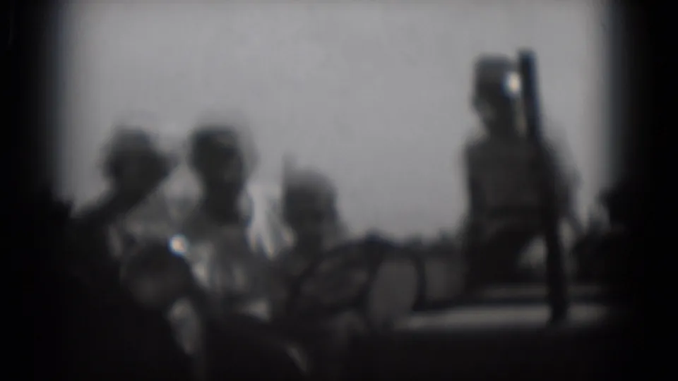 Soft 1975 home-movie frame showing a clustered group of adults outdoors, with a taller figure at the right and heavy film vignetting.