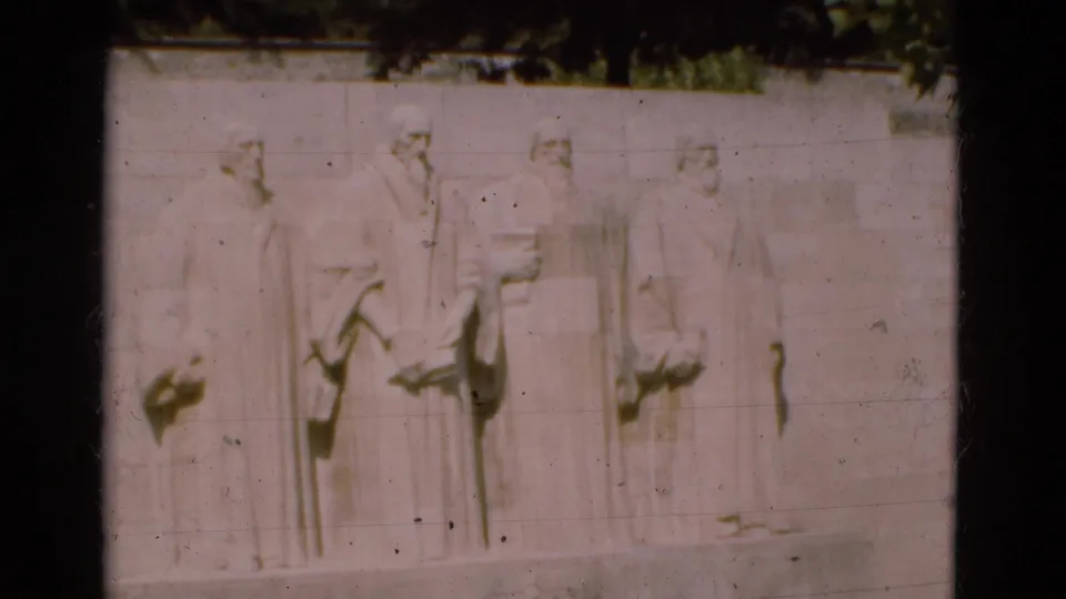 A slightly shifted 1975 Portugal travel frame shows the same pale wall relief with four robed carved figures and visible film wear.