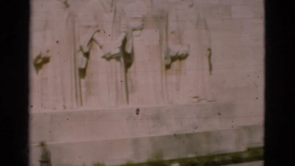 1975 Portugal frame with carved stone figures above a distant person walking along the monument base.
