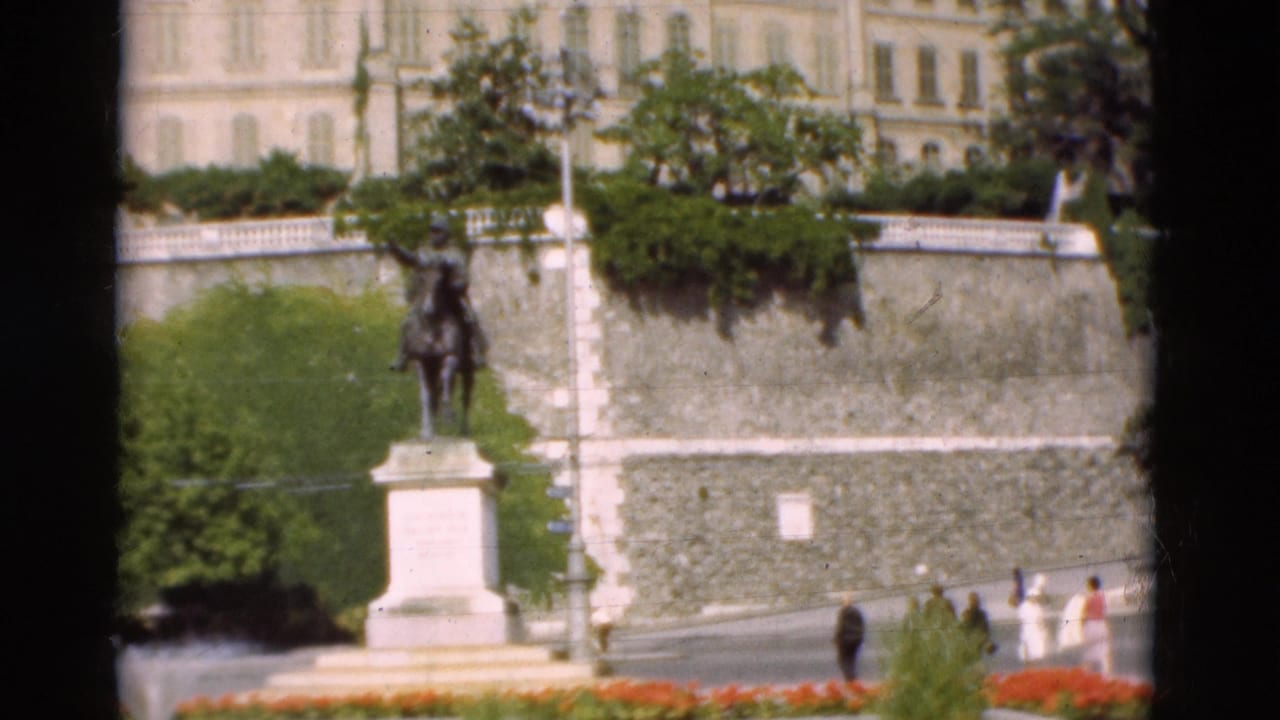 Equestrian statue on a pedestal beside a stone terrace with pedestrians nearby.