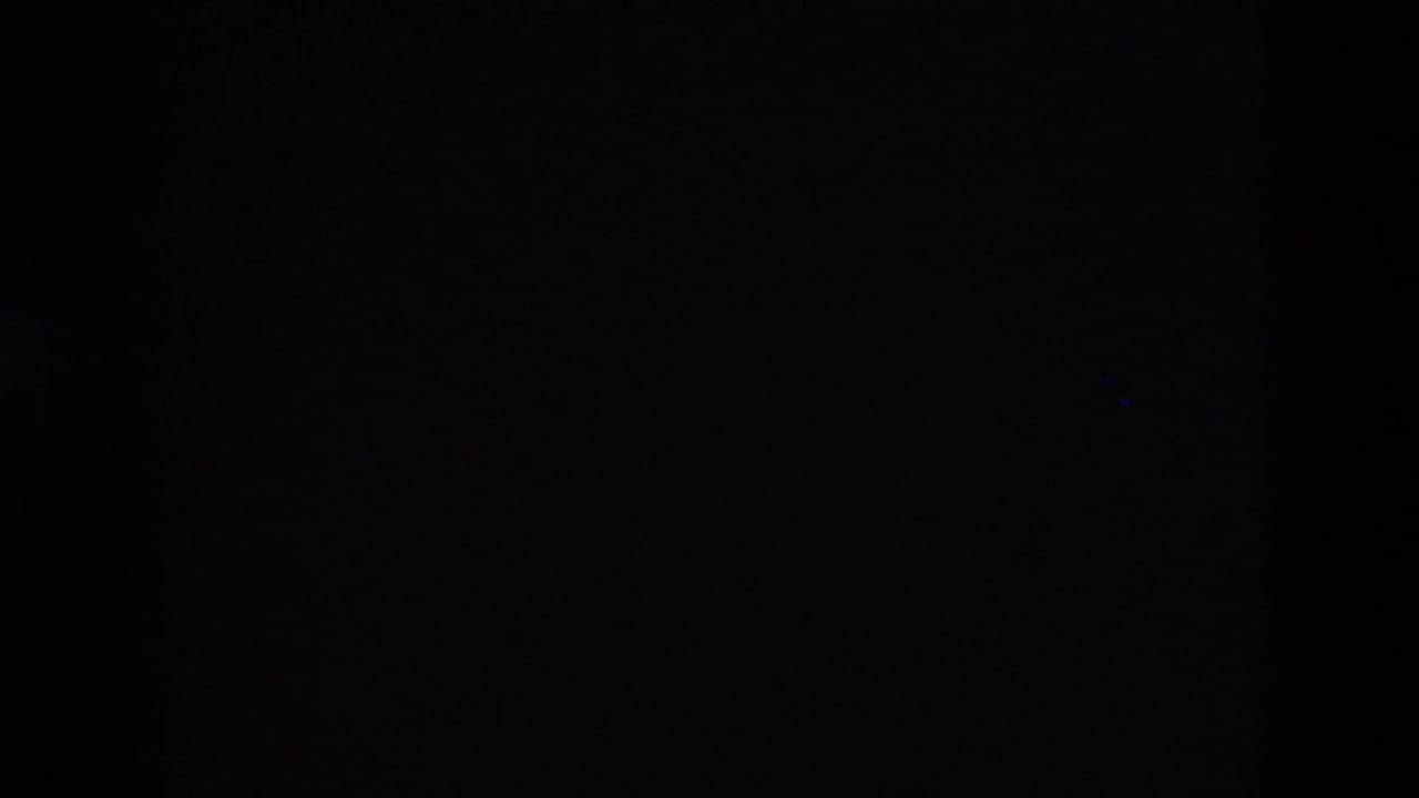 Mostly dark frame with only faint film texture visible.