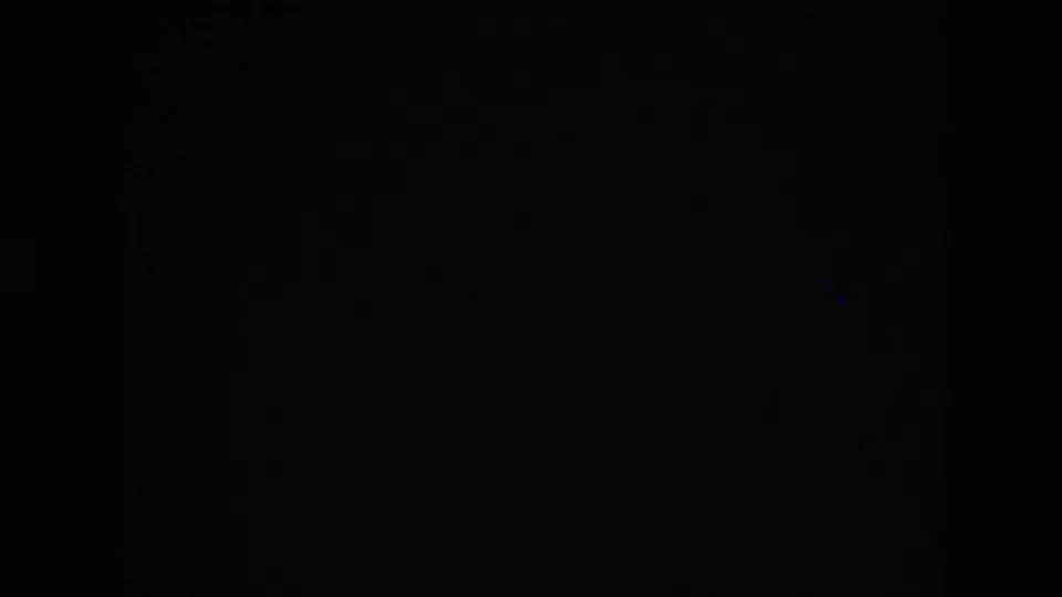 A near-black 8mm frame from the end or obstruction of the Portugal travel clip, with minimal visible detail.