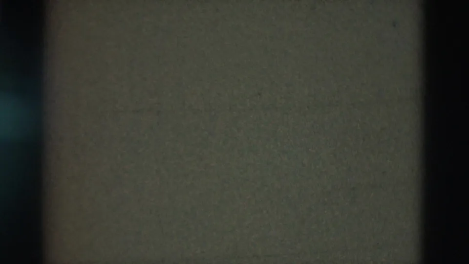 Obscured 1975 Portugal 8mm frame with heavy darkening, a central vertical band, grain, and little readable scene detail.